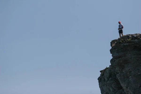Young man on rocky cliff — Stock Photo, Image