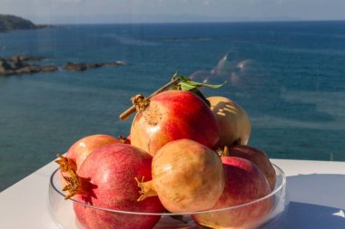 Nar meyve bir kase bir deniz arka plan.