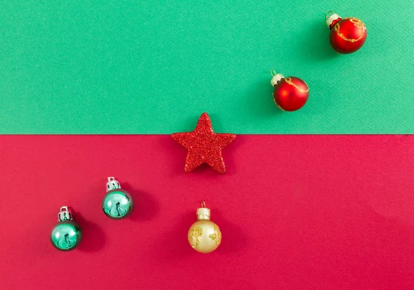 Christmas star and balls arranged diagonally on green and red — Stock Photo, Image