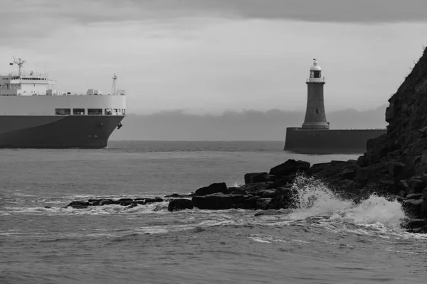 Waves splashing on rocks, lighhouse and cruising Ferryboat, Tyne — Stock Photo, Image