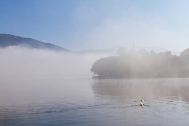 İki kuğu ve Yanya la puslu Morning'de Aslan Paşa Camii