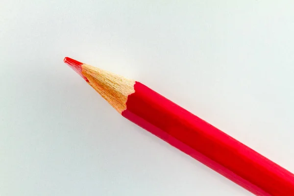 Μολύβι κόκκινου χρώματος σε λευκό χαρτί χρώματος διατεταγμένο διαγώνια. — Φωτογραφία Αρχείου