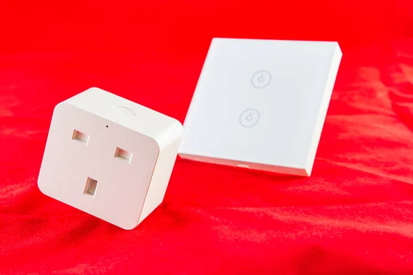 Smart Wi-Fi switch with support for control via mobile  phone application. SHot on red background