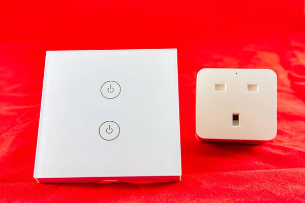 Smart Wi-Fi switch with support for control via mobile  phone application. SHot on red background