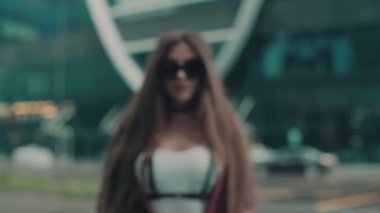 Ağır çekim. Şehirde uzun saçlı genç seksi kız. Swordbelt