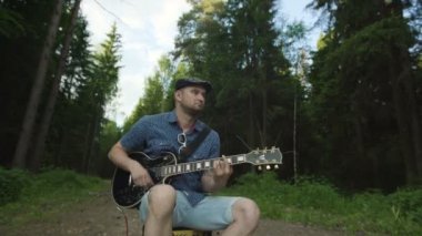 Adam elektro gitar ormandaki yapmaya çalışıyor