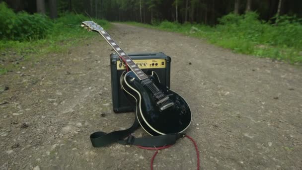 Chitarra elettrica e amplificatore nel bosco — Video Stock