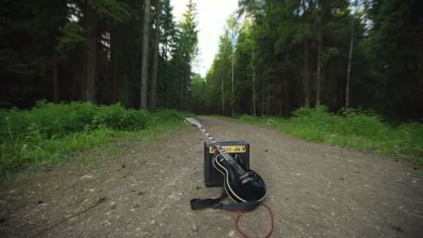 Guitarra eléctrica y amplificador en el bosque — Vídeo de stock