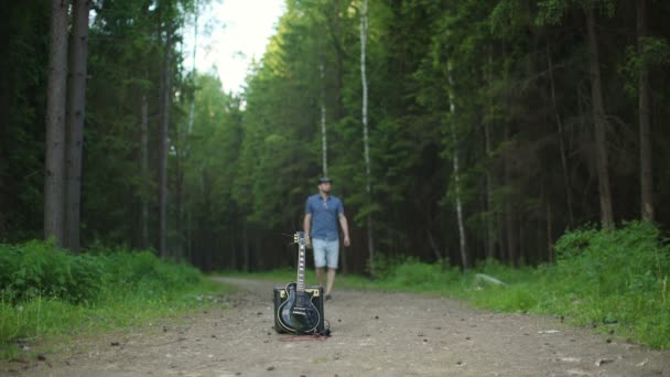Mann spielt im Wald an der E-Gitarre — Stockvideo