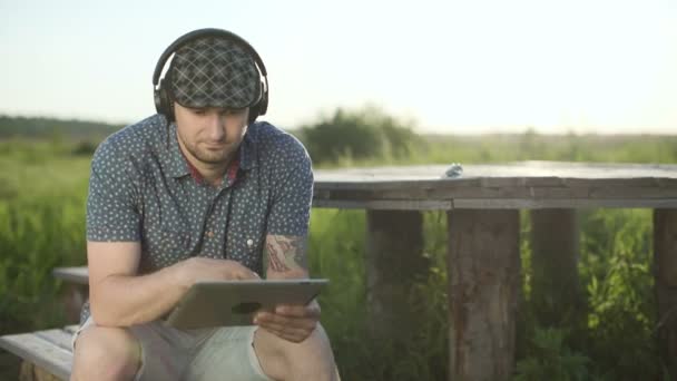 Homme regardant tablette et écouter de la musique — Video