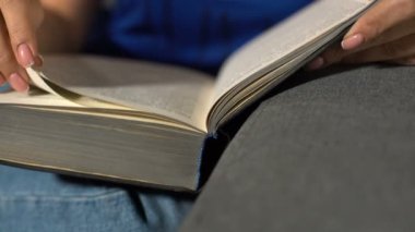 Kız kanepede oturan ve kitap okuma