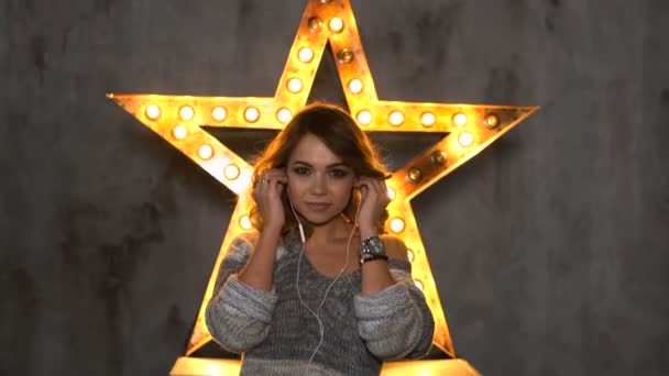 Mujer joven escuchando música en el fondo de las estrellas — Vídeos de Stock