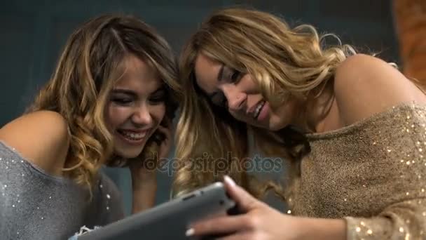 Deux jeunes femmes heureuses regardent la tablette et rient — Video