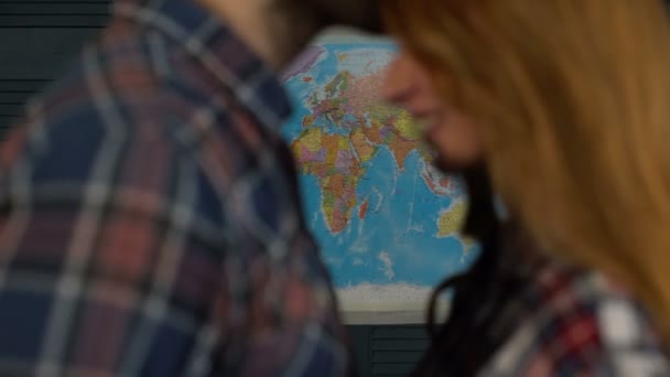 Pareja de turistas jóvenes mirando el mapa del mundo viajará — Vídeo de stock