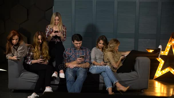 Amigos sentados en el sofá y viendo el teléfono — Vídeos de Stock