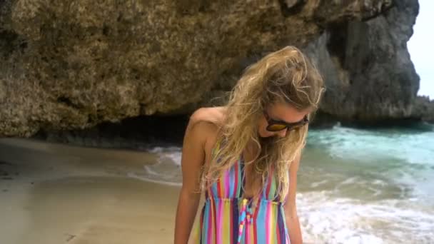 Joven rubia en un vestido brillante corre a lo largo de la playa blanca, sonriendo a la cámara, el desarrollo de pelo . — Vídeos de Stock