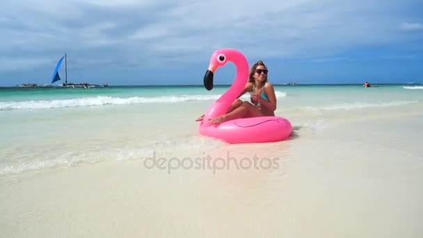 Sexy girl floats on an inflatable mattress on the beautiful white beach with clear water — Stock Video