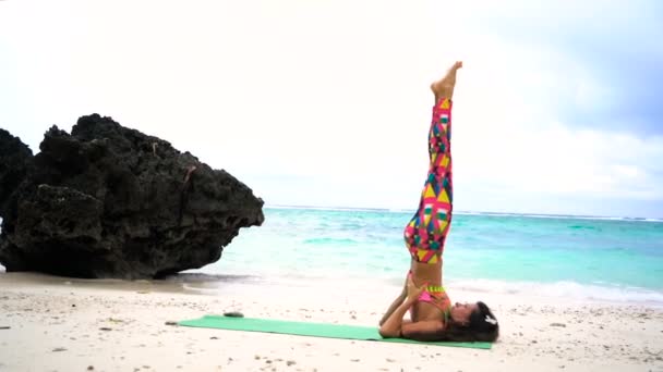 Fille sur la plage pratiquant le yoga — Video