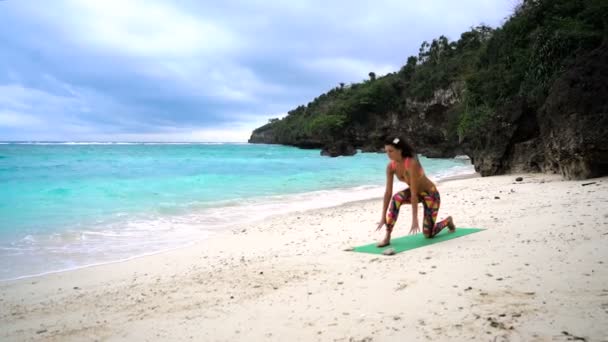 Fille sur la plage pratiquant le yoga — Video