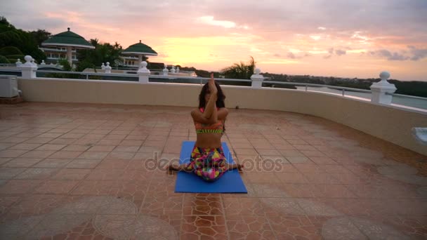 Mädchen bei Sonnenuntergang praktiziert Yoga — Stockvideo