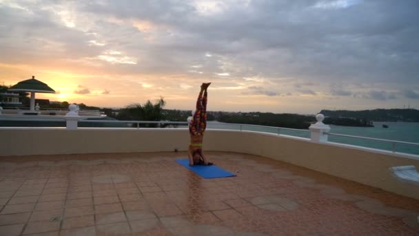 Chica al atardecer practicando yoga — Vídeo de stock