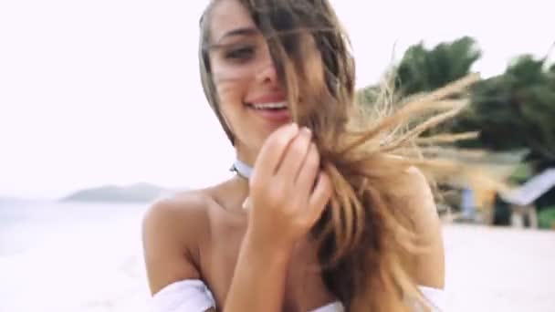 Menina sexy com belo sorriso e cabelos longos rindo na praia e correndo — Vídeo de Stock