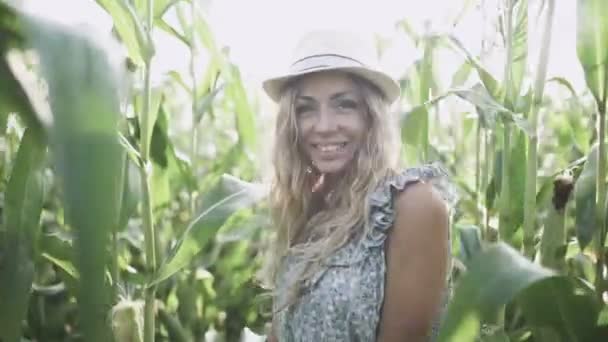 Beautiful girl in hat running and smiling in corn field slow motion — Stock Video