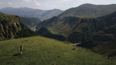 Hava - bir sırt çantası ile dağlarda bir uçuş çevresinde çalışan bir genç kız üzerinde sevinmektedir. Mutluluk ve özgürlük dağlarında hissediyor