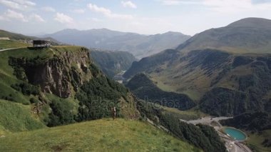 Hava - bir sırt çantası ile dağlarda bir uçuş çevresinde çalışan bir genç kız üzerinde sevinmektedir. Mutluluk ve özgürlük dağlarında hissediyor