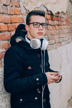 Genç adam akıllı telefon headpho ile müzik dinlemek gülümseyen