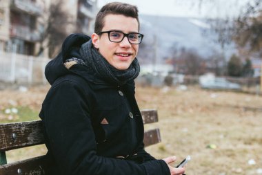 Açık havada akıllı telefon kullanan genç adam