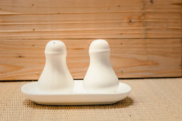 Salt and pepper bottles on wooden background — Stock Photo, Image