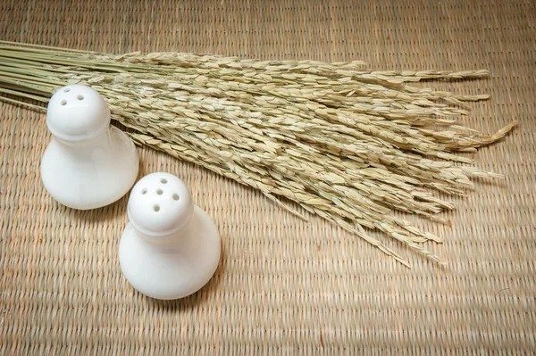 Garrafas de sal e pimenta, arroz no saco no fundo do tapete — Fotografia de Stock