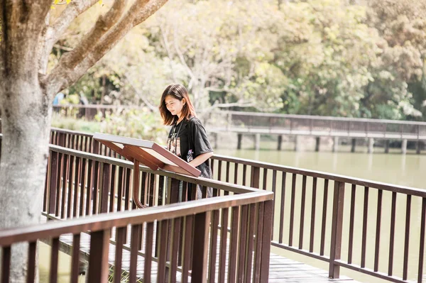 Retrato de una hermosa joven sonriente, Mujer joven atractiva disfrutando de su tiempo fuera en la pasarela en el parque —  Fotos de Stock