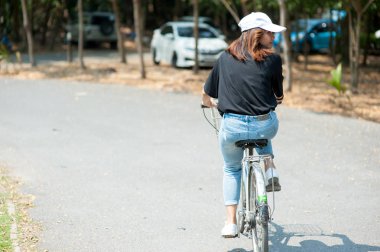 Bangkok, Tayland - 19 Şubat 2017: Bir genç Asyalı kadın / gezgin binme yol ile Kiralama Tayland Sri Nakhon Khuean Khan Park'ta