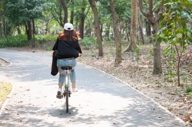 Bangkok, Tayland - 19 Şubat 2017: Bir genç Asyalı kadın / gezgin binme yol ile Kiralama Tayland Sri Nakhon Khuean Khan Park'ta