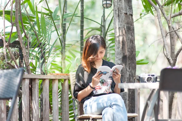 Giovane donna asiatica rilassarsi con la lettura di un libro e pellicola della macchina fotografica in caffè, Stile di vita all'aperto e foto tono vintage — Foto Stock