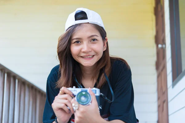 Hipster donna scattare foto con macchina fotografica pellicola retrò sul pavimento in legno del parco della città, bella ragazza fotografata nella vecchia macchina fotografica — Foto Stock