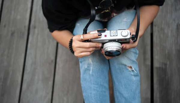 Hipster mulher tirar fotos com câmera de filme retro no chão de madeirado parque da cidade, linda menina fotografada na câmera velha — Fotografia de Stock