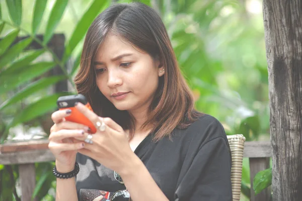 Közeli kép a női kéz használata a modern okos telefon, míg a dolgozó, fiatal nő, egy érintőképernyős okostelefon segítségével másol hely — Stock Fotó