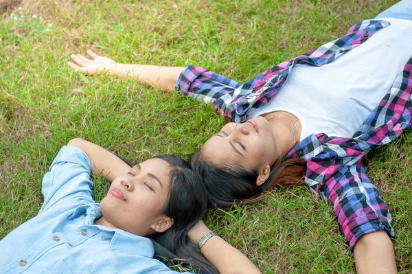 Dwie młode kobiety, piękna dziewczyna jest relaks, leżąc na trawie w parku — Zdjęcie stockowe