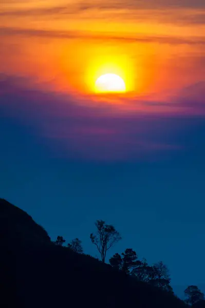 Puesta de sol en las montañas, silueta del árbol con el sol puesta del sol escénico sobre el fondo colorido del cielo . —  Fotos de Stock