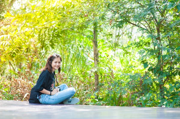 Retrato de uma bela menina sorridente, jovem atraente desfrutando de seu tempo fora na passarela no parque — Fotografia de Stock