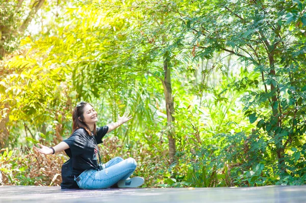 Retrato de uma bela menina sorridente, jovem atraente desfrutando de seu tempo fora na passarela no parque — Fotografia de Stock