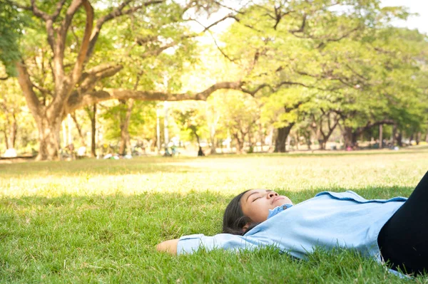 Bella giovane donna rilassante al parco, in prati erbosi verdi . — Foto Stock