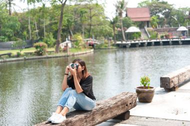 Açık Şehir Parkı, güzel kız eski fotoğraf makinesi içinde fotoğraflandı retro film kamera ile fotoğraf çekmek hipster kadın
