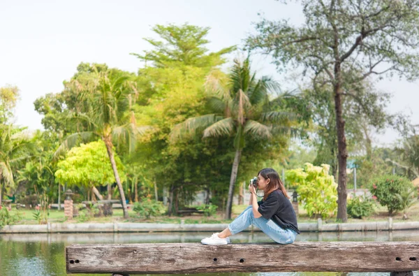 Hipster mulher tirar fotos com câmera de filme retro no parque da cidade ao ar livre, linda menina fotografada na câmera velha — Fotografia de Stock