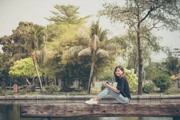 Hipster donna scattare foto con macchina fotografica retrò film nel parco cittadino all'aperto, bella ragazza fotografata nella vecchia macchina fotografica — Foto Stock