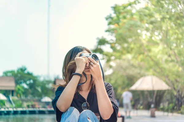 Hipster γυναίκα λαμβάνοντας φωτογραφίες με κάμερα ρετρό ταινία στο υπαίθριο Δημοτικό Πάρκο, όμορφο κορίτσι που φωτογραφήθηκε στην παλιά κάμερα — Φωτογραφία Αρχείου