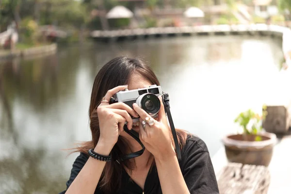 Hipster donna scattare foto con macchina fotografica retrò film nel parco cittadino all'aperto, bella ragazza fotografata nella vecchia macchina fotografica — Foto Stock